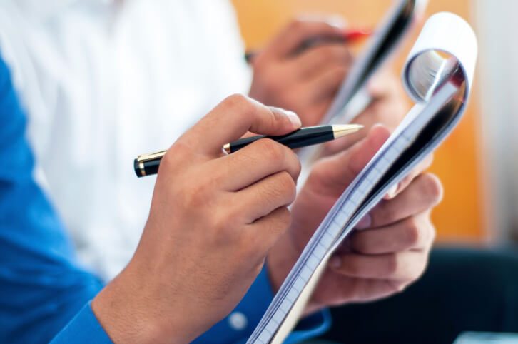 Business people writing on notepad