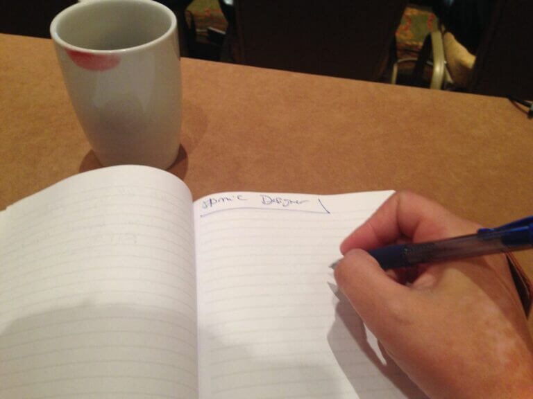 hand with pen near notebook