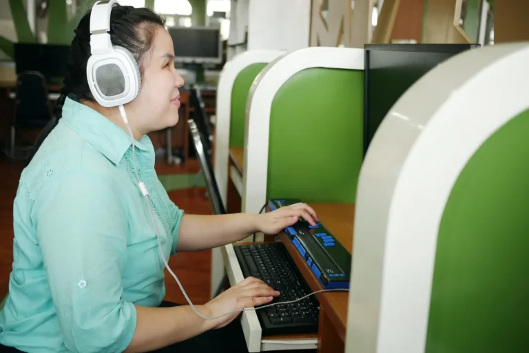 Considering an accessibility overlay? Think twice. 2 Asian woman with blindness disability using computer with refreshable braille display or braille terminal a technology assistive device for persons with visual impairment in workplace.