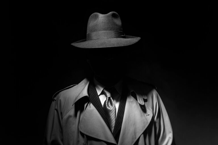 Your WordPress Site Is Being Attacked Right Now. AI Just Made It Worse. 7 Man posing in the dark with a fedora hat and a trench coat, 1950s noir film style character